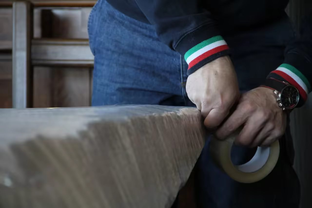 Addetto Iacone Traslochi che applica il nastro adesivo su un imballaggio